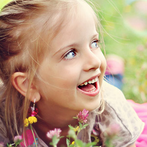 young girl outside laying in flowers