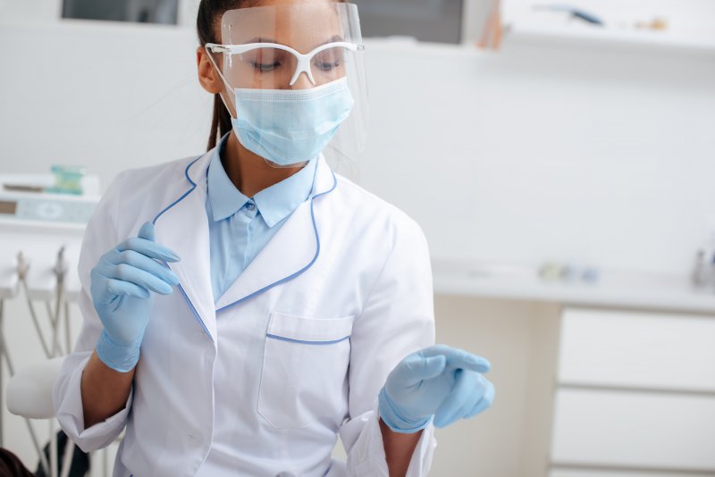 a dentist using personal protective equipment inside the dental practice to keep everyone safe