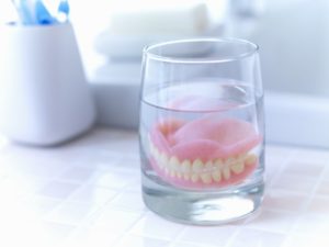 dentures in Jacksonville soaking in glass of water