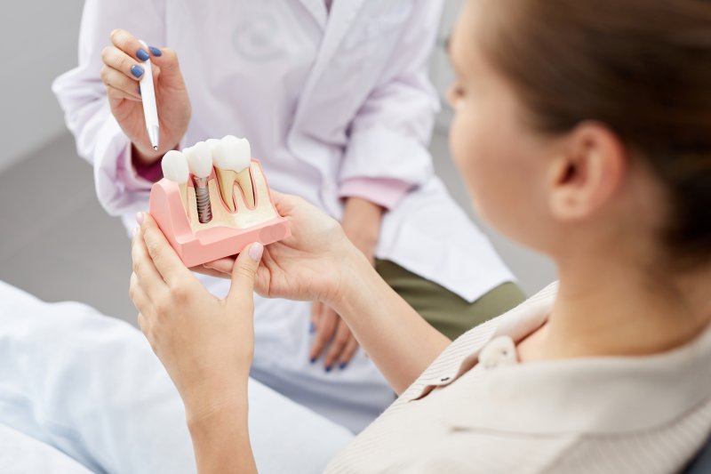 dentist showing a patient a dental implant